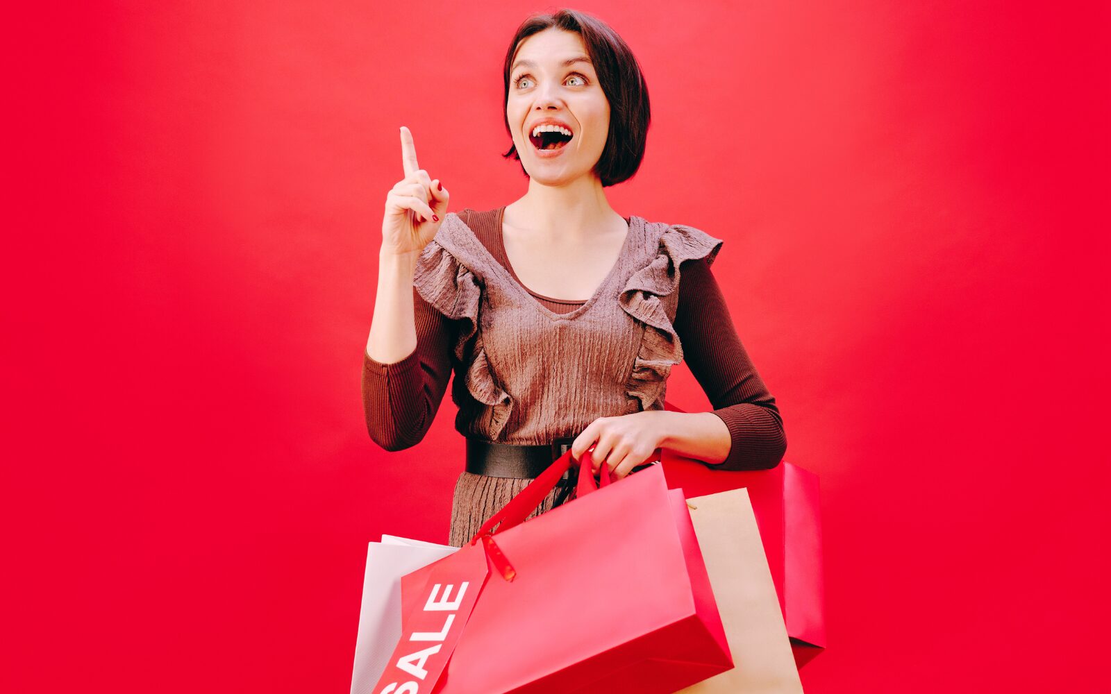 Woman looking ecstatic for Amazon Prime Big Deal Days, Walmart Deals Holiday Kickoff, Target, and Best Buy while holding shopping bags with the word sale